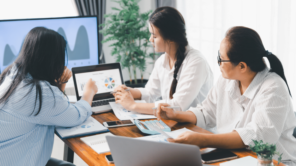 Team analyzing charts and data in a business meeting, illustrating Pinterest’s effectiveness as a visual-driven sales and marketing channel.